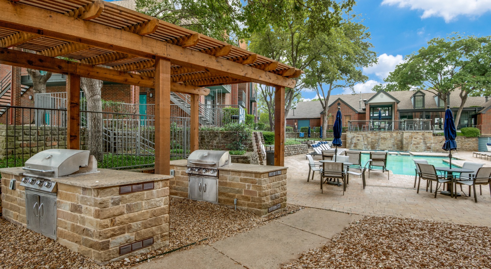 a pool and grill area at The Hyde Park at Valley Ranch