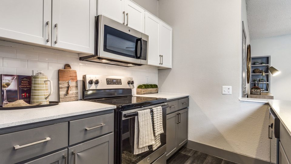 a kitchen with stainless steel appliances and a microwave at The Hyde Park at Valley Ranch