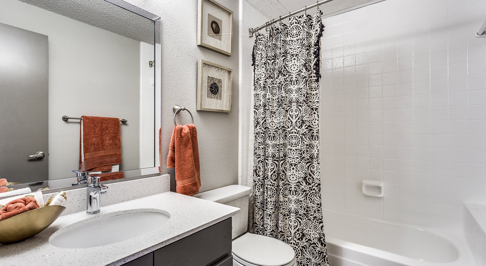 a bathroom with a shower curtain and toilet at The Hyde Park at Valley Ranch
