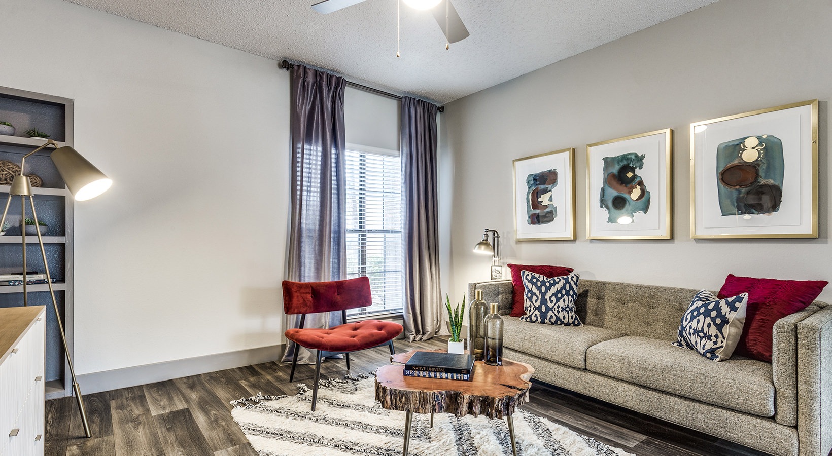 a living room with a couch, chair and a rug at The Hyde Park at Valley Ranch