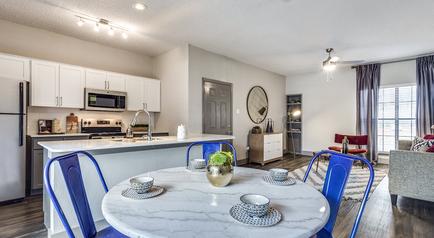 a kitchen and dining area in a modern apartment at The Hyde Park at Valley Ranch