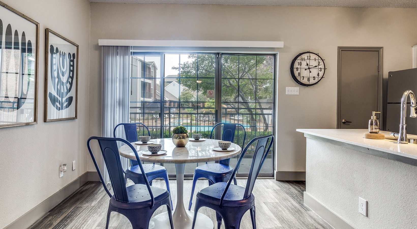 a kitchen with blue chairs and a table at The Hyde Park at Valley Ranch