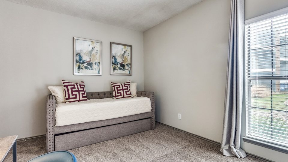 a bedroom with a bed and a window at The Hyde Park at Valley Ranch