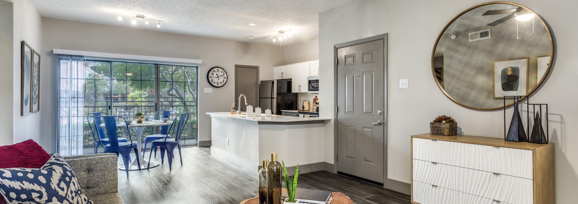 the living room and kitchen area of a home at The Hyde Park at Valley Ranch