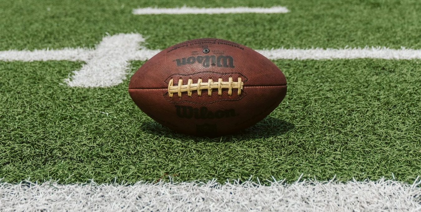 an american football sits on the field at The Hyde Park at Valley Ranch